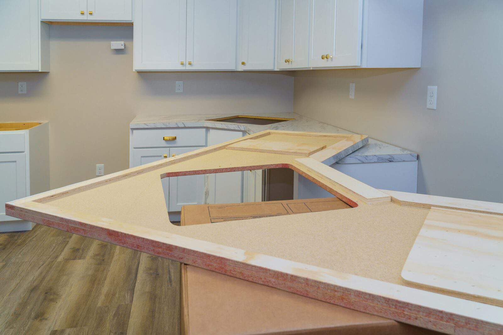Installing cabinets and laminate kitchen counter top furniture in kitchen.