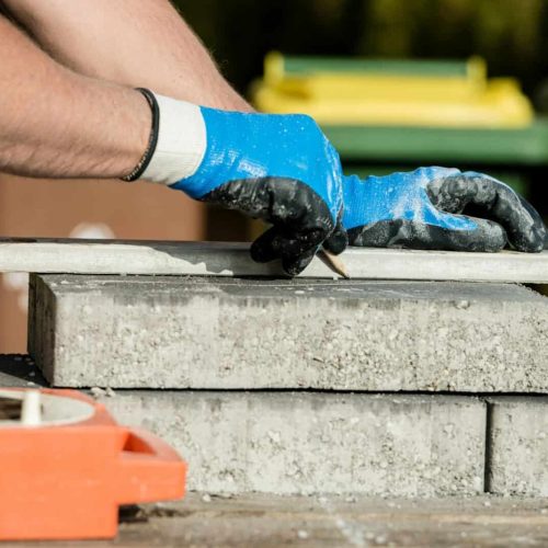 Builder marking a paving stone or block to cut