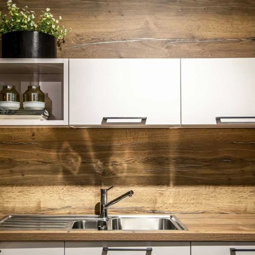 Modern wooden kitchen interior, steel kitchen faucet.