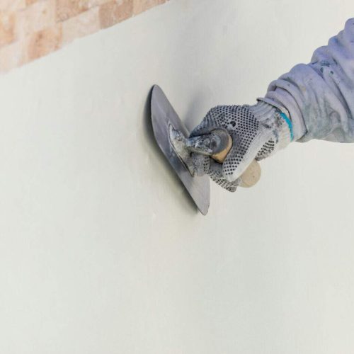 Worker Smoothing Wet Pool Plaster With Trowel